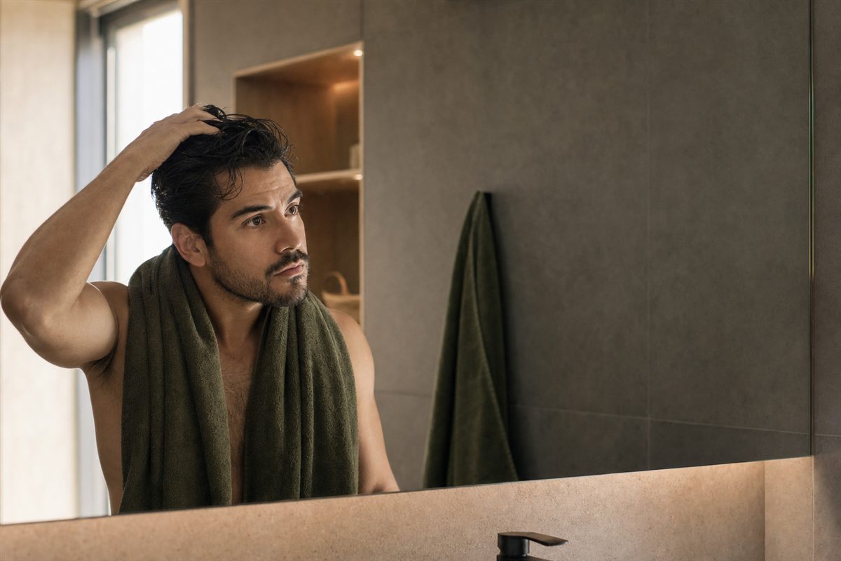 Hombre revisando su cabello durante su rutina diaria